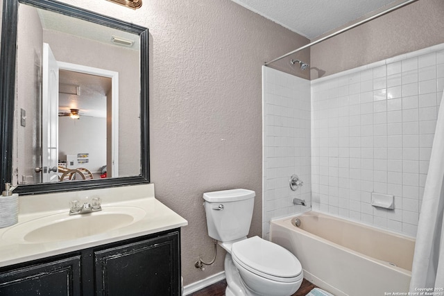 bathroom featuring toilet, a textured wall, vanity, and visible vents