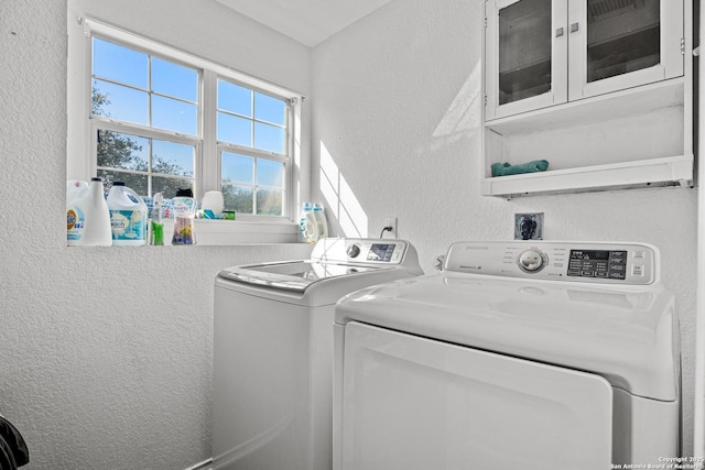 laundry room featuring washer and clothes dryer and a textured wall