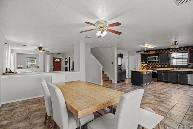 dining space with plenty of natural light, visible vents, and stairway