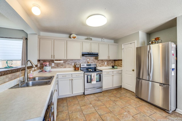 kitchen featuring decorative backsplash, stainless steel appliances, light countertops, under cabinet range hood, and a sink