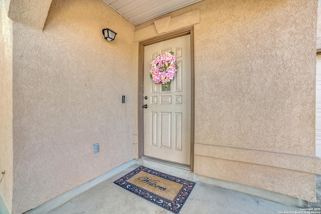 entrance to property featuring stucco siding