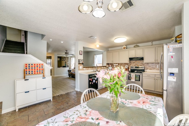 dining space featuring a ceiling fan, baseboards, visible vents, and a textured ceiling