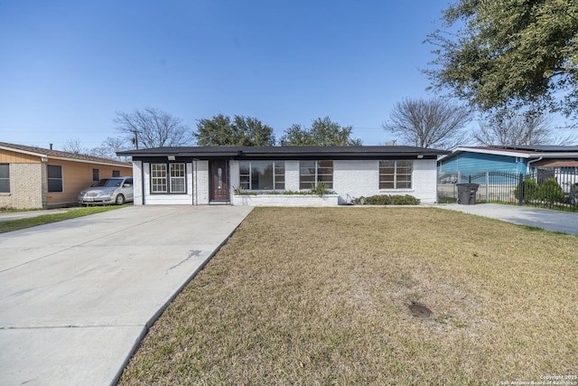 ranch-style house with brick siding, fence, concrete driveway, and a front yard