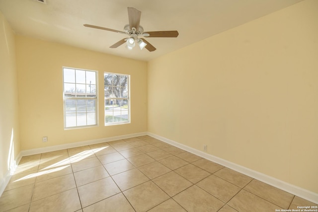 unfurnished room featuring light tile patterned flooring, ceiling fan, and baseboards