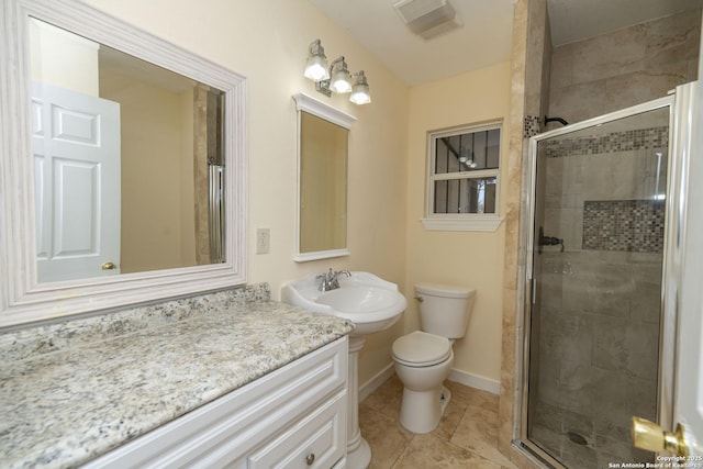 bathroom featuring a sink, a shower stall, toilet, and baseboards