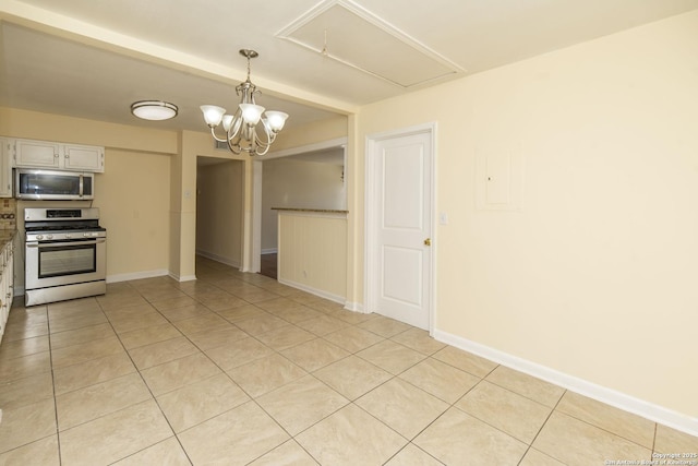 kitchen with light tile patterned floors, hanging light fixtures, an inviting chandelier, appliances with stainless steel finishes, and baseboards