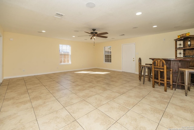 unfurnished room with visible vents, a bar, and light tile patterned floors