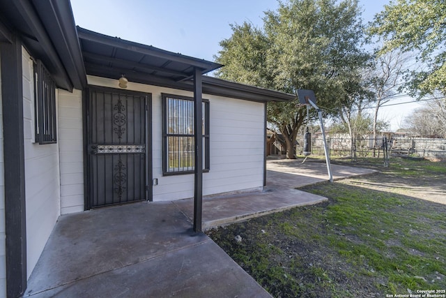 entrance to property with a patio area and fence