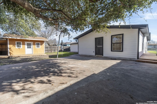 view of front facade with fence, driveway, and an outdoor structure