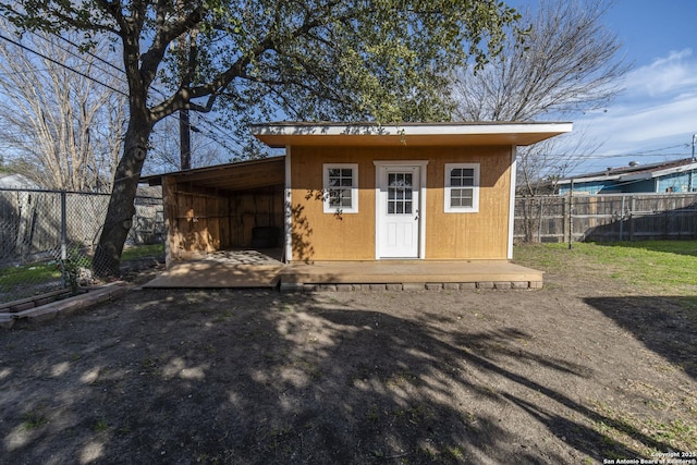 view of outdoor structure featuring a fenced backyard and an outbuilding