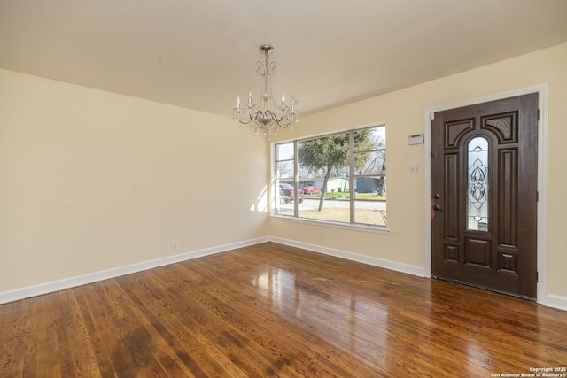 foyer with baseboards, dark wood-style flooring, and an inviting chandelier