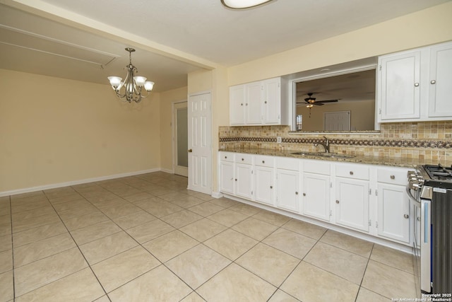 kitchen featuring backsplash, a ceiling fan, gas stove, white cabinetry, and a sink