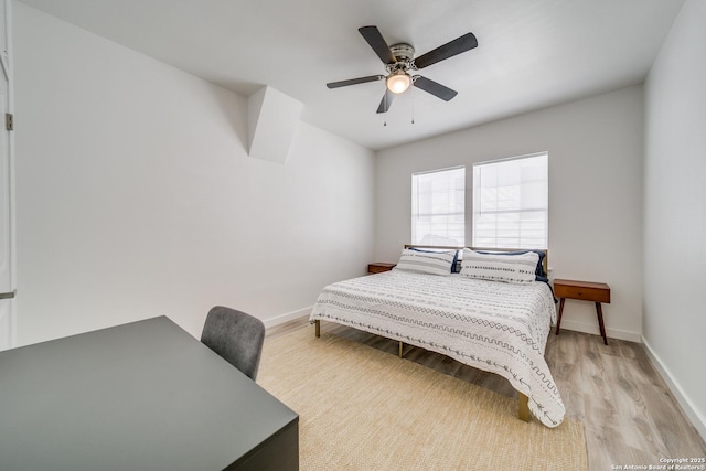 bedroom with a ceiling fan, light wood-type flooring, and baseboards