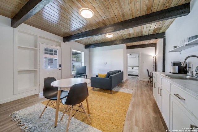 dining area featuring light wood-type flooring, wooden ceiling, built in shelves, and beam ceiling