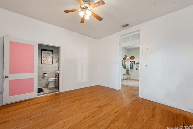 spare room with light wood-type flooring, visible vents, and ceiling fan