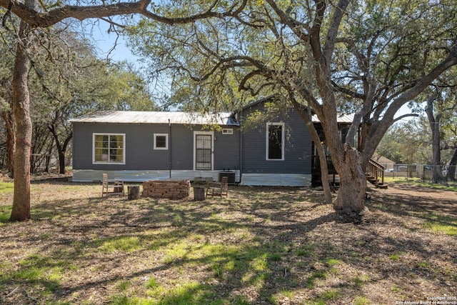 rear view of property with fence and metal roof