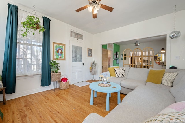 living room with light wood-type flooring and a ceiling fan