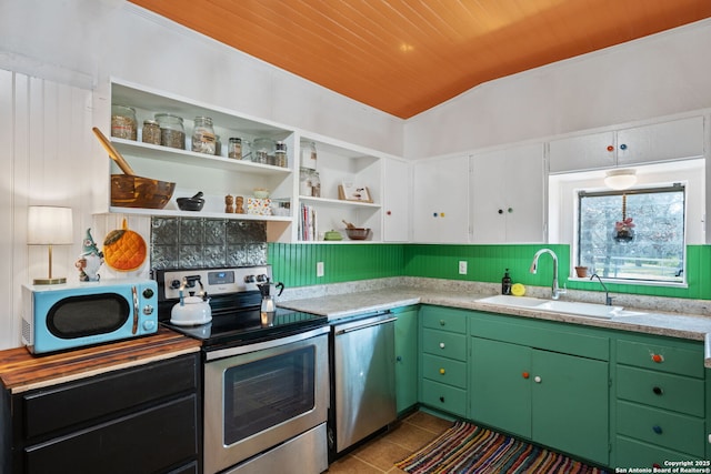 kitchen featuring dark tile patterned flooring, stainless steel appliances, a sink, and light countertops