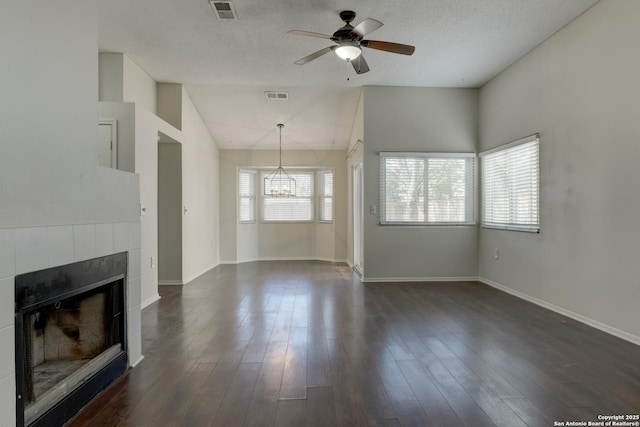 unfurnished living room with a wealth of natural light, visible vents, and ceiling fan with notable chandelier