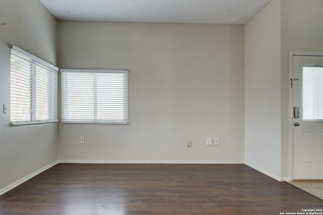 unfurnished room featuring baseboards and wood finished floors