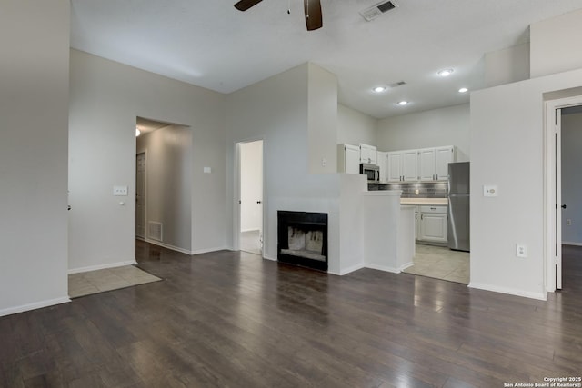 unfurnished living room with visible vents, ceiling fan, and wood finished floors