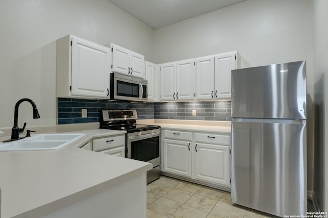 kitchen with a sink, stainless steel appliances, backsplash, and light countertops