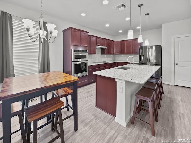 2832 Klein Way, New Braunfels, TX 78130 - kitchen featuring stainless steel appliances, backsplash, a sink, dark brown cabinets, and under cabinet range hood