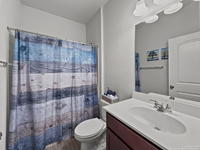 2832 Klein Way, New Braunfels, TX 78130 - bathroom featuring a textured wall, toilet, a shower with shower curtain, wood finished floors, and vanity