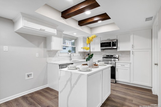 kitchen with appliances with stainless steel finishes, visible vents, a sink, and decorative backsplash