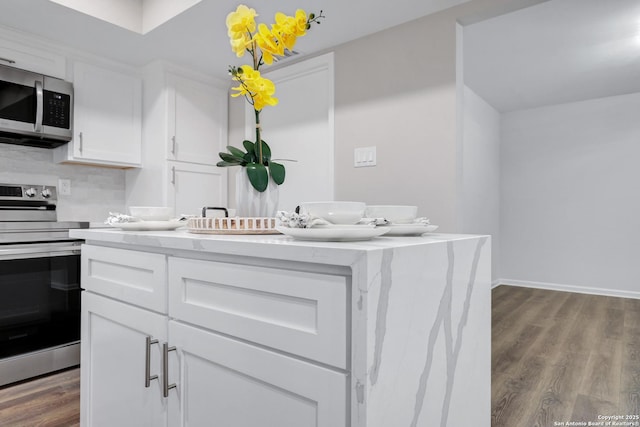 kitchen with stainless steel appliances, baseboards, white cabinets, backsplash, and dark wood-style floors