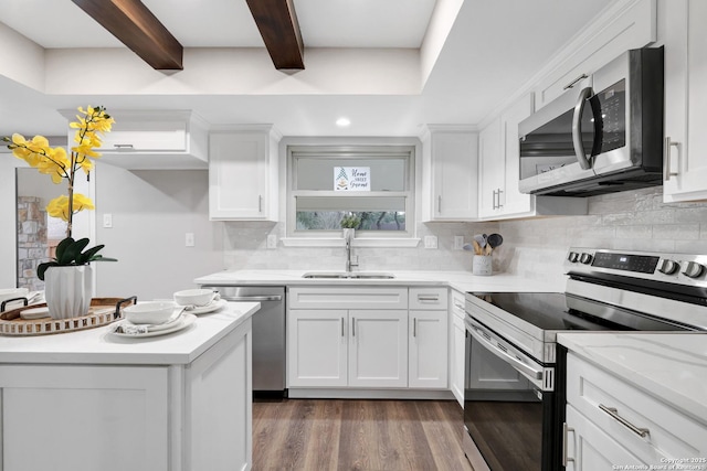 kitchen featuring stainless steel appliances, decorative backsplash, white cabinets, a sink, and beamed ceiling