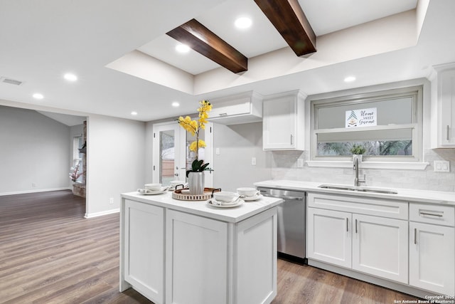 kitchen featuring a wealth of natural light, white cabinets, dishwasher, and a sink