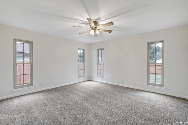 carpeted empty room with ceiling fan and baseboards