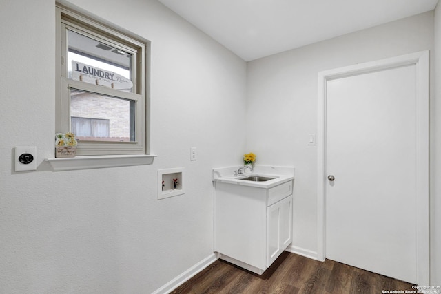 clothes washing area featuring cabinet space, baseboards, dark wood-type flooring, washer hookup, and a sink