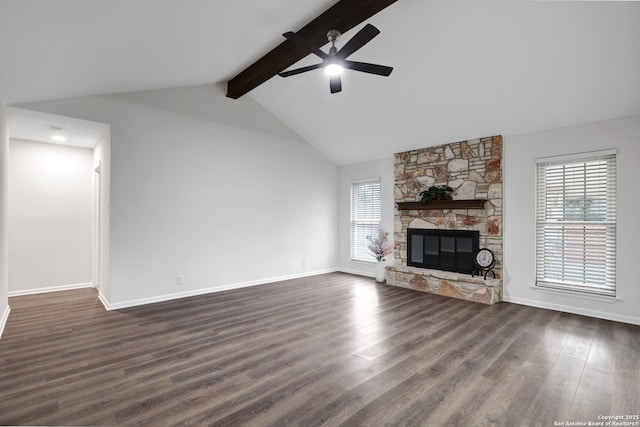 unfurnished living room with a stone fireplace, a ceiling fan, baseboards, dark wood-style floors, and beamed ceiling