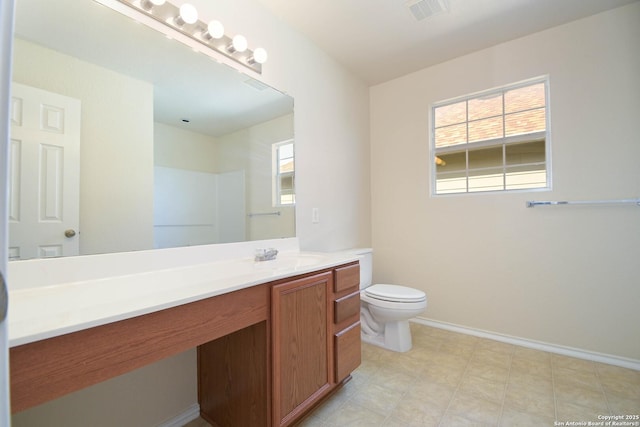 bathroom with baseboards, visible vents, vanity, and toilet