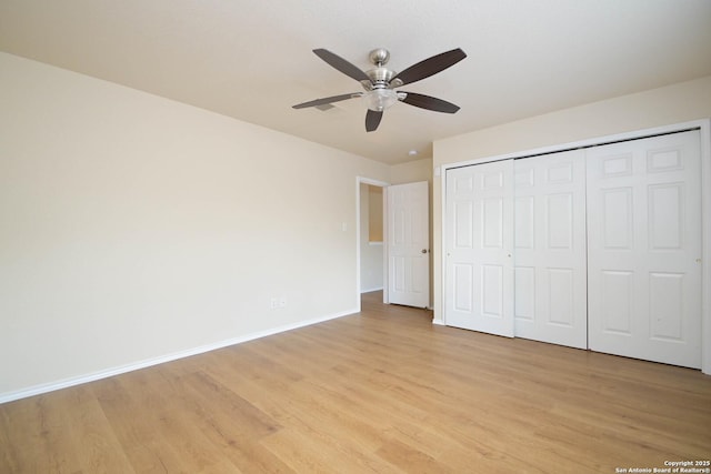 unfurnished bedroom featuring light wood-style floors, a closet, baseboards, and a ceiling fan