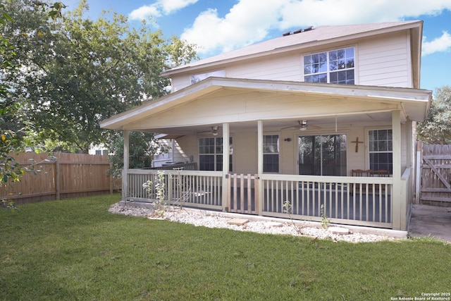 view of front facade with ceiling fan, fence, and a front yard