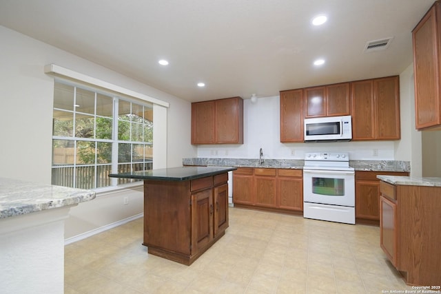 kitchen featuring white appliances, visible vents, a sink, and recessed lighting