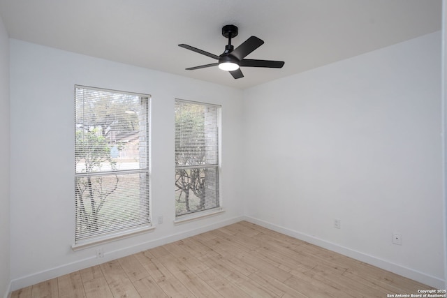 spare room featuring light wood-type flooring, ceiling fan, and baseboards