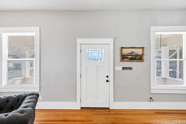 entryway with baseboards and wood finished floors