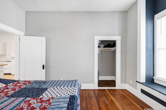 bedroom with wood finished floors and baseboards