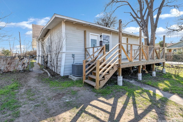 rear view of property with a shingled roof, a gate, fence, a wooden deck, and central AC