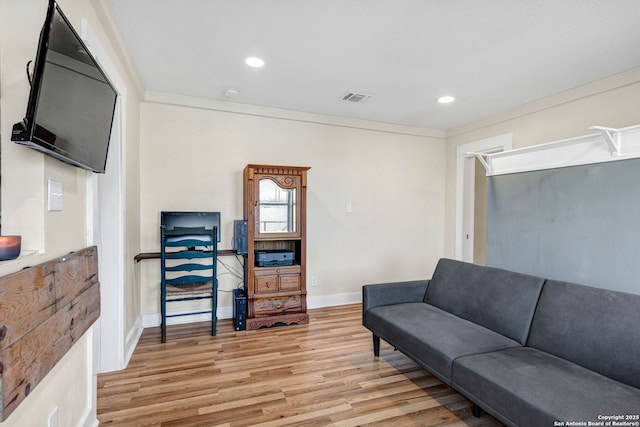 living area with baseboards, light wood finished floors, visible vents, and recessed lighting