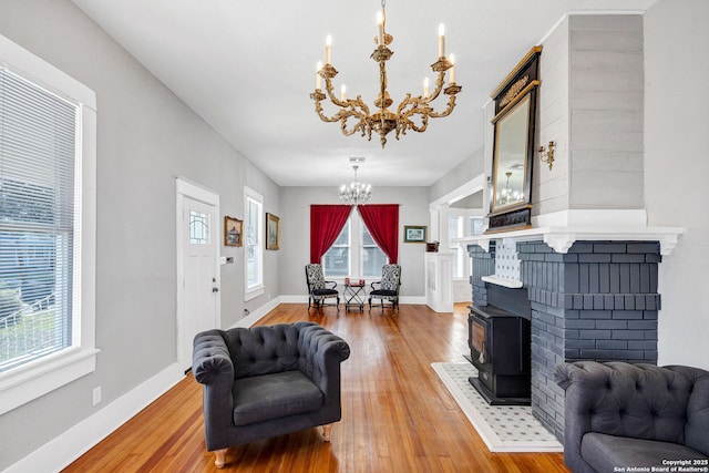 living room featuring baseboards, light wood finished floors, and an inviting chandelier