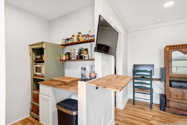 kitchen with baseboards, white cabinets, butcher block counters, light wood-type flooring, and open shelves