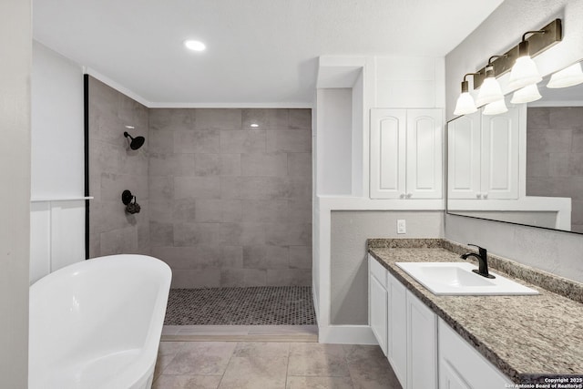 bathroom featuring a freestanding bath, tiled shower, and vanity