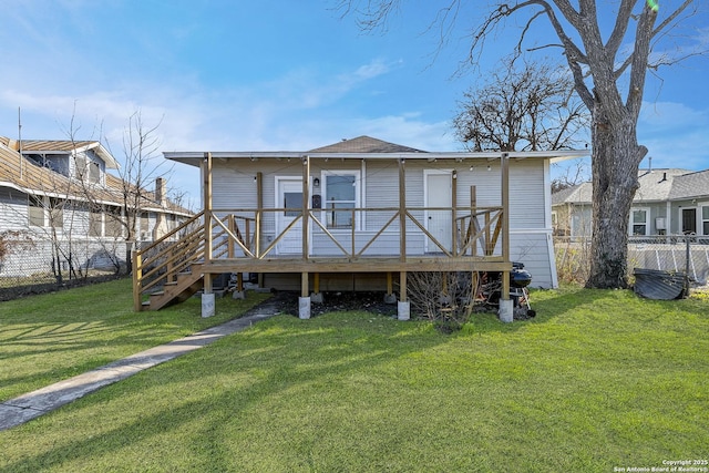 rear view of property featuring stairs, fence, a deck, and a lawn