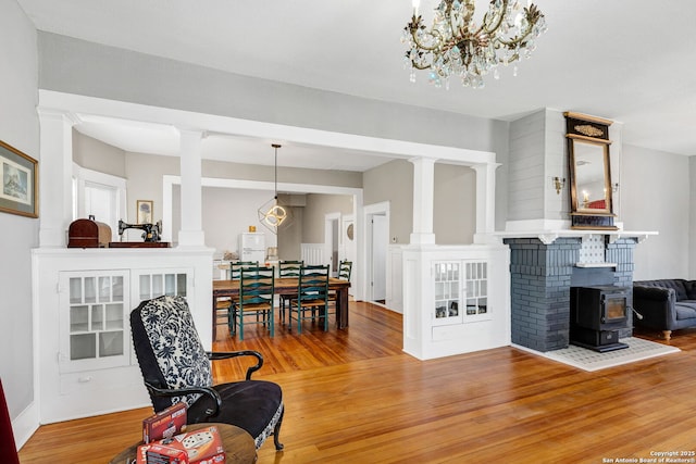 living area with wood finished floors and decorative columns