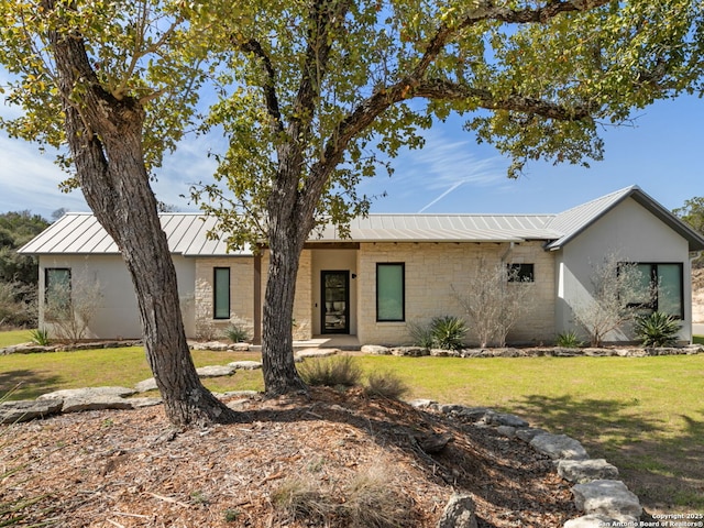 view of front of property featuring metal roof, brick siding, a standing seam roof, and a front yard